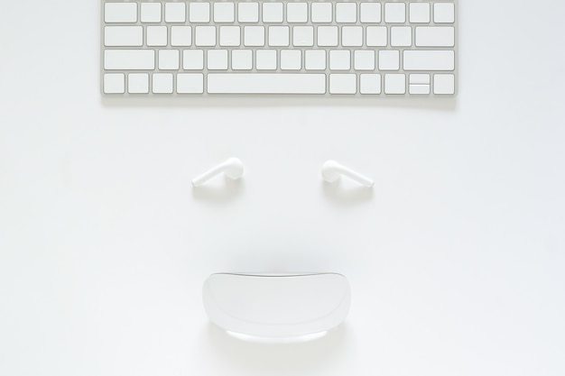 Flat lay of keyboard, earphone and mouse set as smiling face on white background for cyber monday online sale concept. Premium Photo