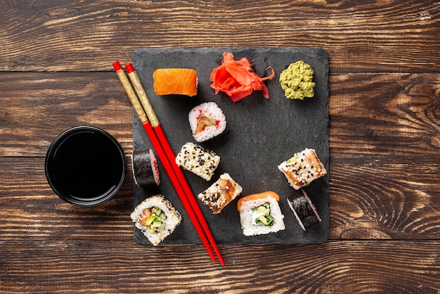 Flat lay mix of maki sushi rolls with chopsticks Free Photo