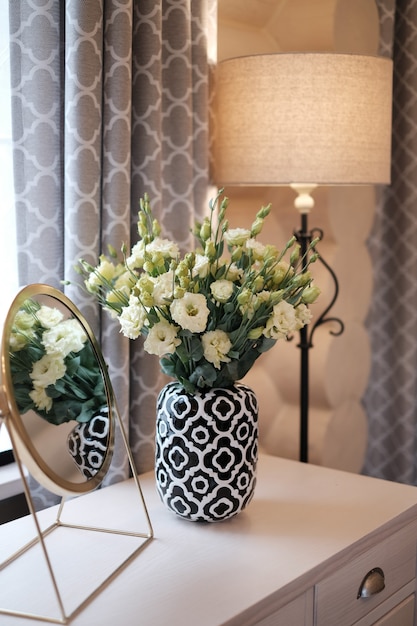 Premium Photo Flowerpot With Flowers On White Desk Lamp And Mirror Near Window In Modern Home Interior