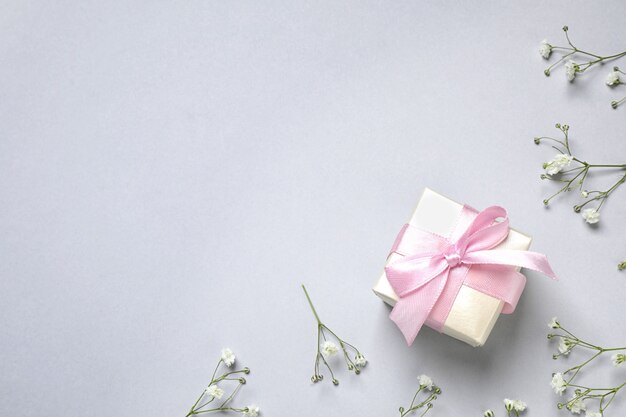 Premium Photo | Flowers, gift and space for text on light grey ...