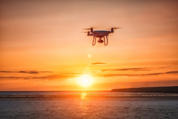 Premium Photo | Flying drone on a background of sea sunset