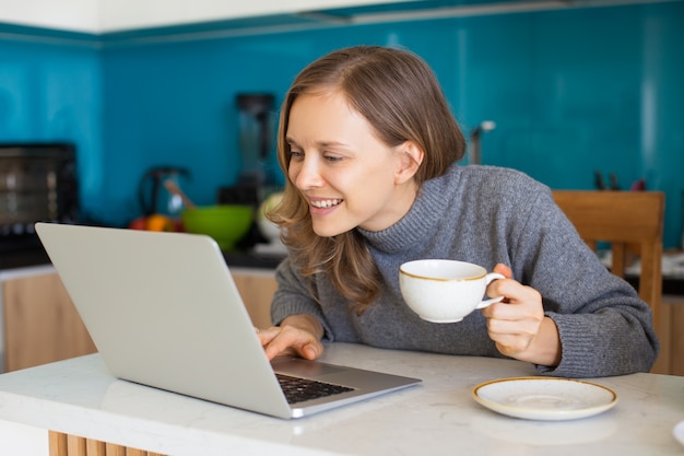 Focused Beautiful Lady Browsing on Laptop at Home Premium Photo