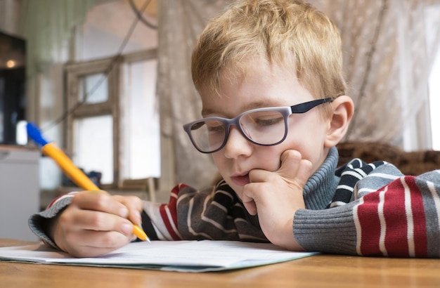 Premium Photo | Focused first grader learning to write and doing homework.