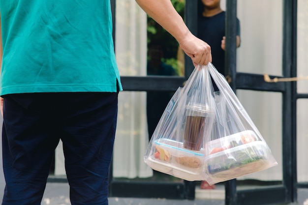 Premium Photo | Food boxes in plastic bags delivered to customer at home by  delivery man