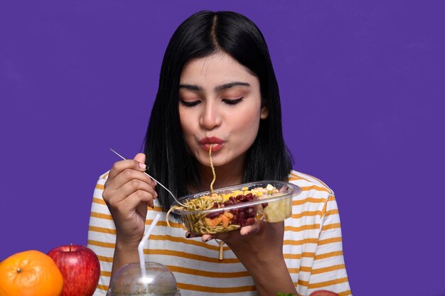 Premium Photo Foodie Girl Sitting At Fruit Table Eating Spaghetti