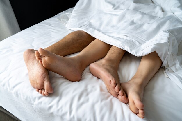 Premium Photo | Foot man and girl be tired on the bed, couple bed story