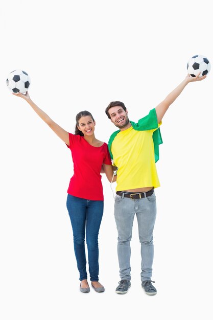 Football fan couple cheering and smiling at camera Premium Photo