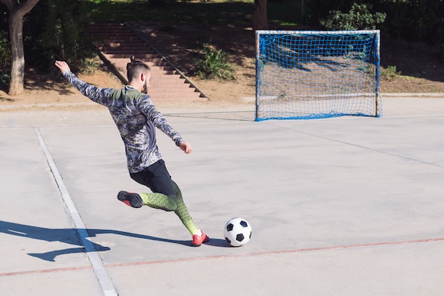 Premium Photo Football Player Kicking The Ball Into Empty Goal