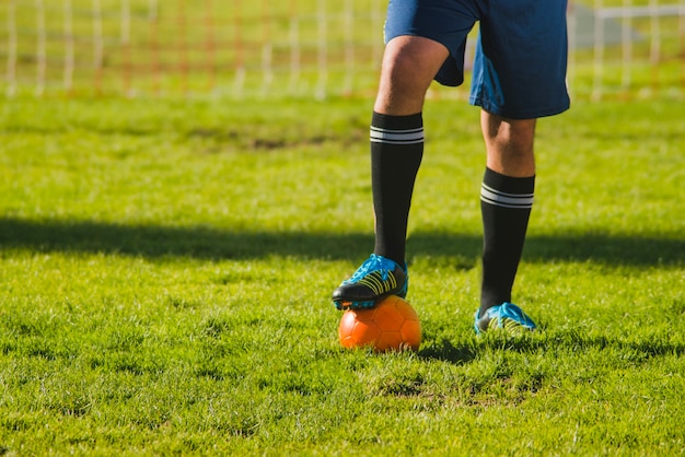 サッカー選手がボールに彼の足を置きます 無料の写真