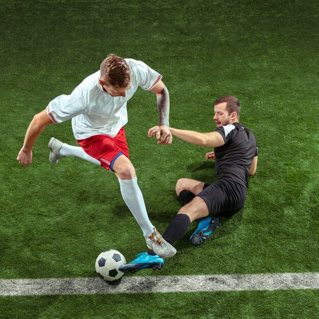 Free Photo | Football player tackling for ball over green grass wall