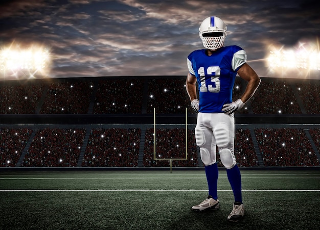 Premium Photo | Football player with a blue uniform on a stadium