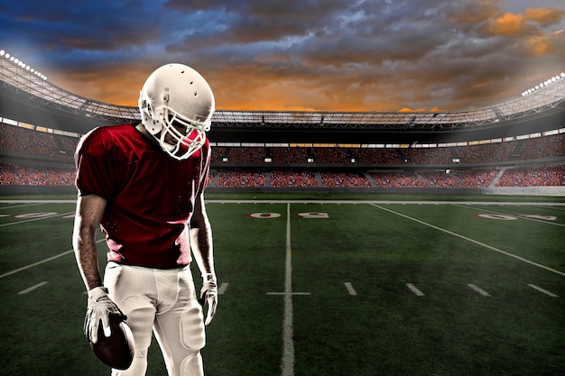 Premium Photo | Football player with a red uniform, in a stadium with ...