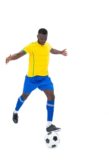 Premium Photo | Football player in yellow kicking ball on white background