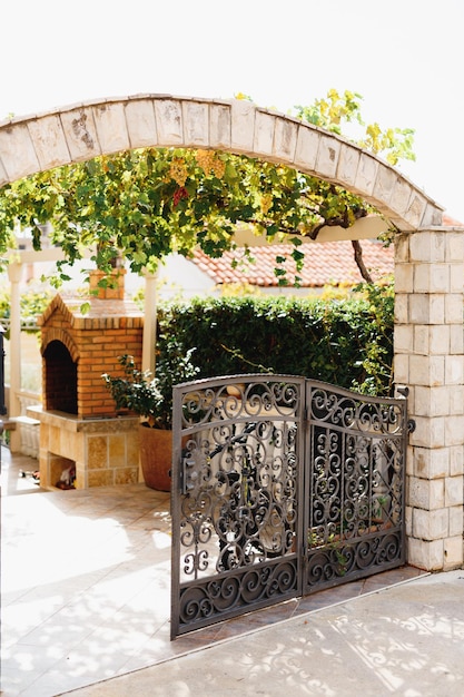 Premium Photo Forged Metal Gate In A Brick Fence Of A Private Courtyard