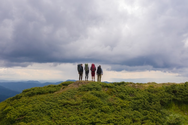 Premium Photo | The four active people standing on the picturesque mountain