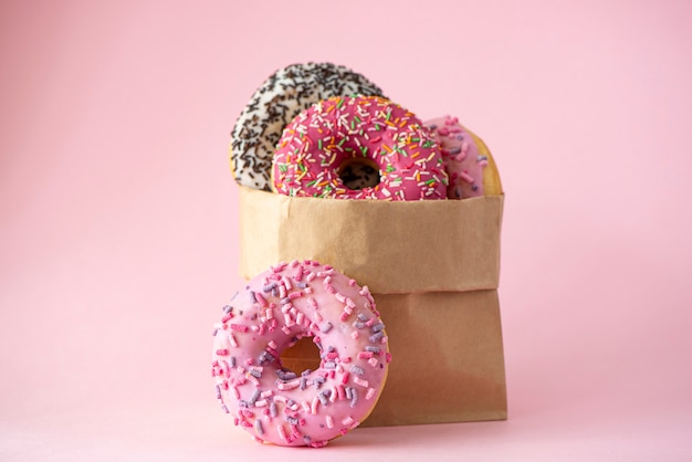 Download Premium Photo | Four donuts with glaze in a paper bag