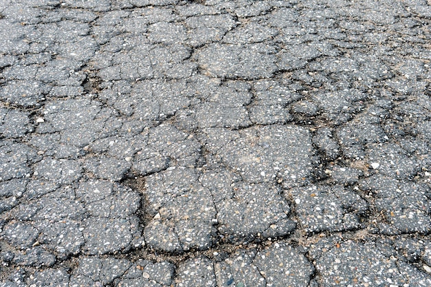 Фрагмент русской сельской дороги с потрескавшимся асфальтом текстура старого сломанного асфальта | Премиум Фото