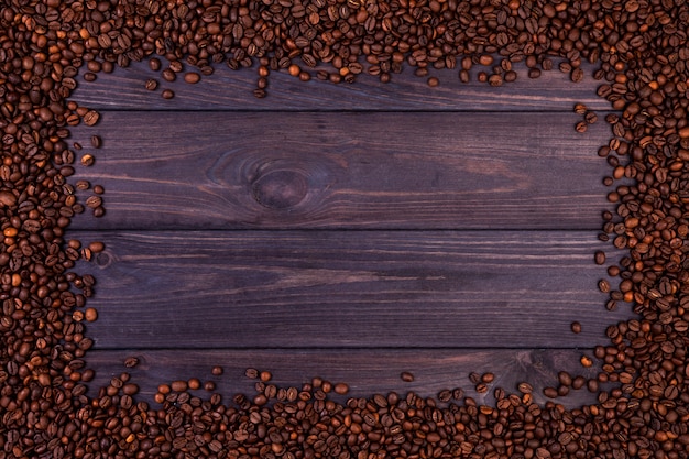 Frame of coffee beans on dark wooden background. top view with copy space Premium Photo