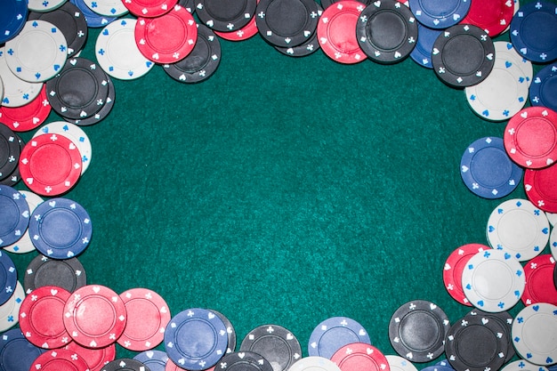 Frame made with casino chips on green poker table Free Photo