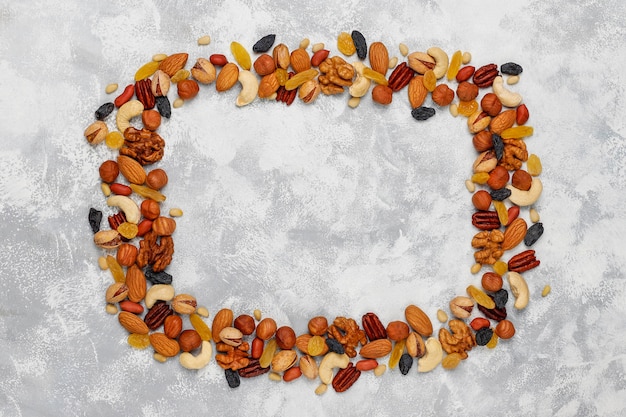 Frame of various nuts, cashew, hazelnuts, walnuts, pistachio, pecans, pine nuts, peanut, raisins.top view Free Photo