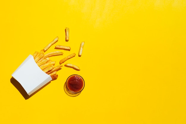 Download Premium Photo French Fries With Ketchup On Yellow Background PSD Mockup Templates