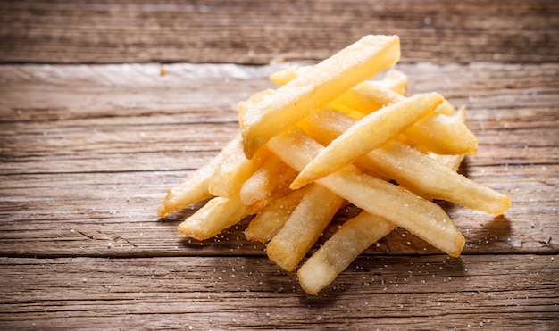 Premium Photo | French fries on wood background