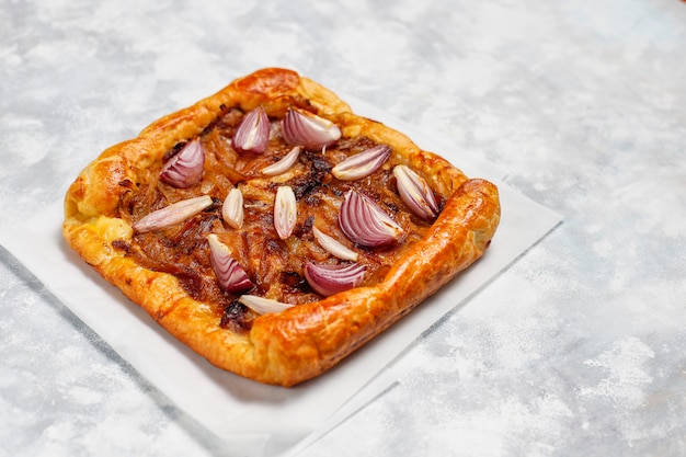 French style onion pie galette with puff pastry and various onions shallot,red,white,yellow onions,top view Free Photo