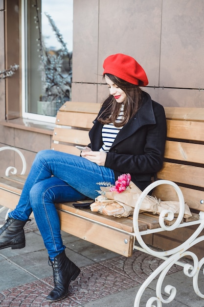 Free Photo | French woman in a red beret on a street bench