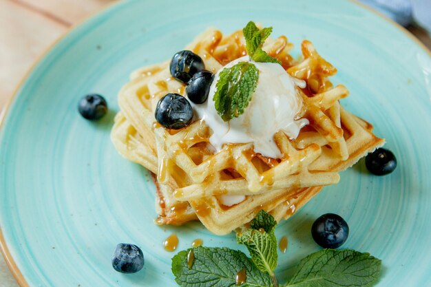 Fresh Baked Homemade Classic Belgian Waffles Topped With Icecream Fresh Blueberries And Mint On Wooden Background Top Down View Breakfast Concept Premium Photo