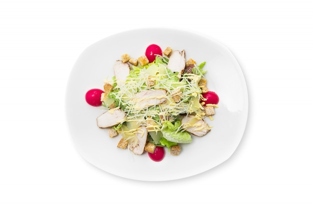 Fresh caesar salad with chicken on a white plate isolated. Premium Photo