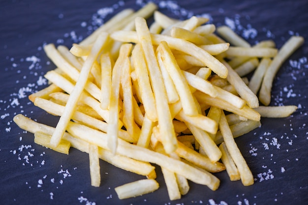 Premium Photo Fresh french fries with salt on black plate photo