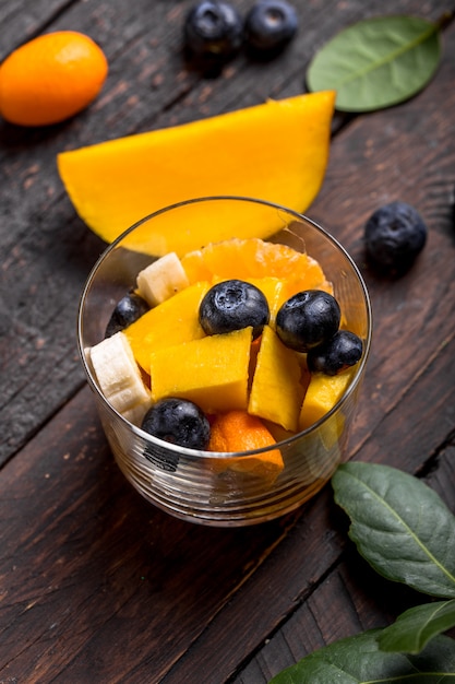 Download Premium Photo Fresh Fruit Salad With Various Kind Of Berry And Citrus Fruit Mango Served In Glass Bowl Placed On Wooden Table