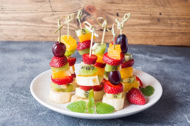 Premium Photo | Fresh fruit on skewers.