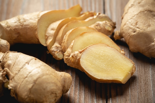 Fresh ginger root and sliced on wooden table. Free Photo