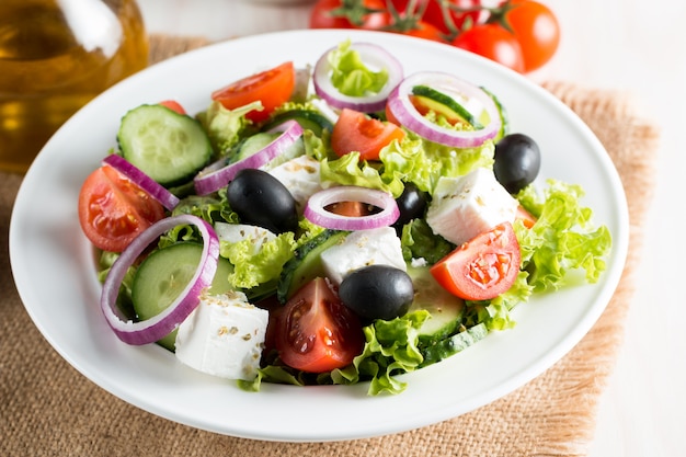 Fresh greek salad made of cherry tomato, ruccola, arugula, feta, olives, cucumbers, onion and spices. Premium Photo
