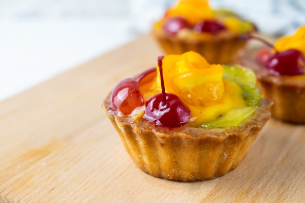 Fresh homemade mini fruit tarts with orange cherry kiwi and grapes Premium Photo