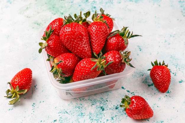 Fresh juicy strawberries in plastic lunch box on light | Free Photo