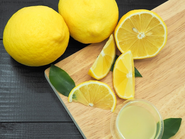 Premium Photo | Fresh lemon juice in small bowl and lemon slice on dark wood background