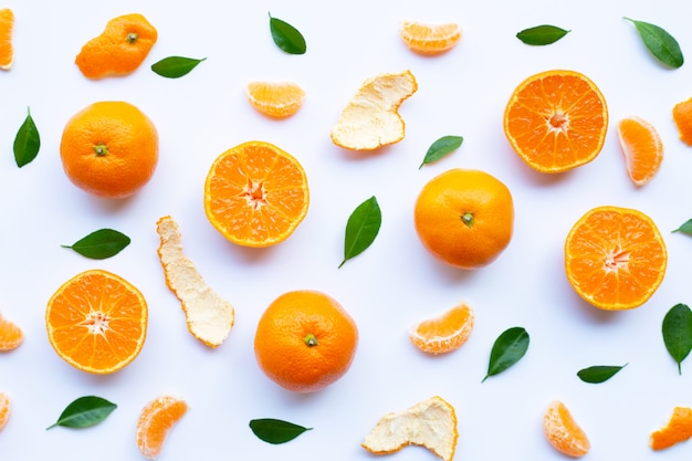 Fresh orange citrus fruit with peel and green leaves on white Premium Photo