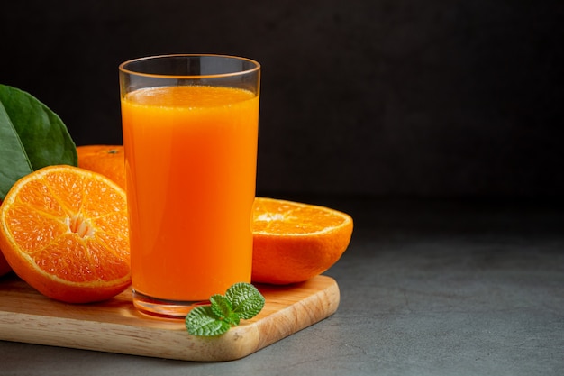 Fresh orange juice in the glass on dark background Free Photo