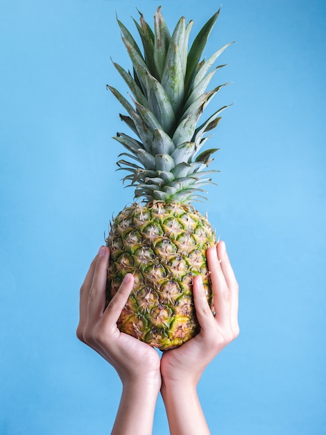 Premium Photo | Fresh pineapple being held by a pair of hands