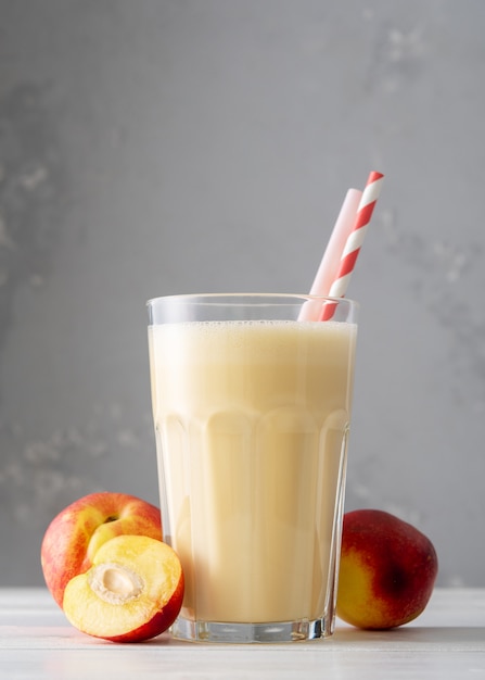 Premium Photo | Fresh protein shake with nectarine or peach on a white ...