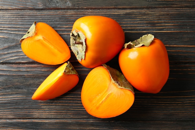 Premium Photo | Fresh ripe persimmon on wooden background, top view