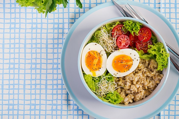 Fresh salad. breakfast bowl with oatmeal, tomatoes, lettuce ...