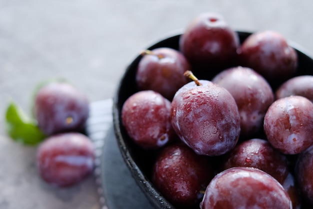 Fresh violet plums at dark gray table background Premium Photo