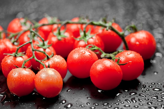 Premium Photo | Fresh wet organic cherry tomatoes bunch closeup on black.