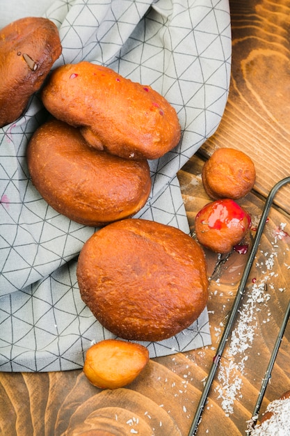 Freshly baked donut bread on table cloth over wooden table Free Photo