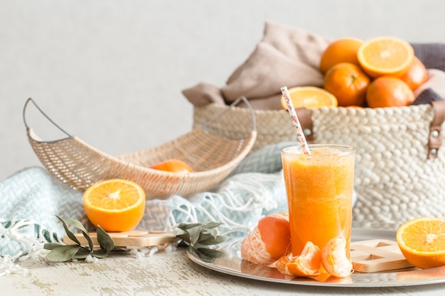 ターコイズブルーの毛布とフルーツバスケットが付いた 家の内部にある新鮮な有機フレッシュオレンジジュース 健康食品 ビタミンc 無料の写真