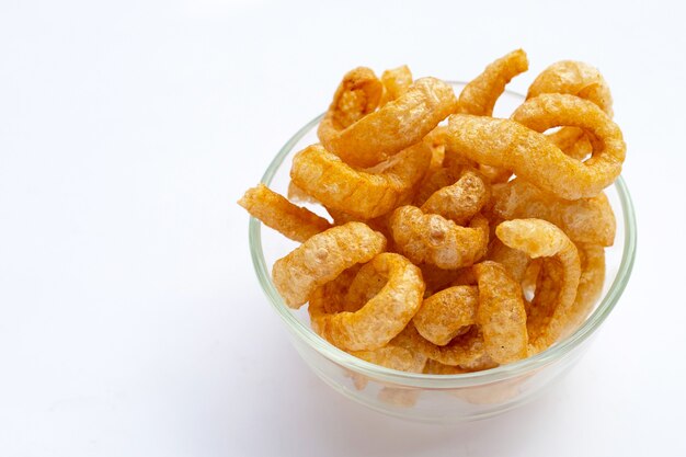 Premium Photo | Fried crispy pork rinds in glass bowl on white background.