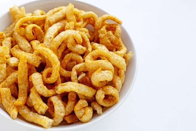 Premium Photo | Fried crispy pork rinds in white bowl on white background.